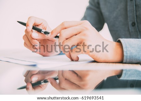 Businessman sitting at table with pen in hands