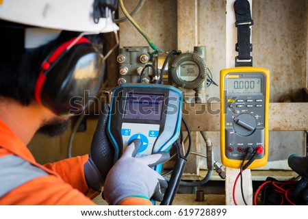 Technician,Instrument technician on the job calibrate or function check pneumatic control valve in process oil and gas platform offshore, Royalty-Free Stock Photo #619728899