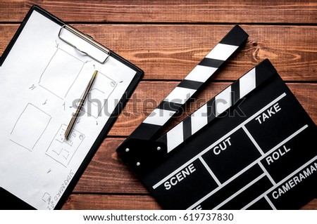 Screenwriter desktop with movie clapper board wooden background 