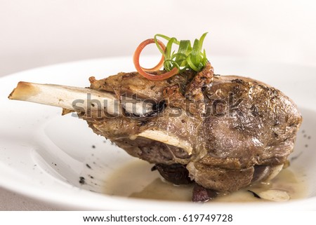Roasted turkey leg, served with white sauce, decorated with herbs, placed on white plate, light background, isolated