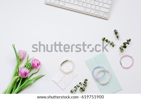 Spring flowers on workdesk at home white background top view mockup