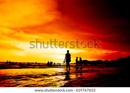 Silhouette Tourists on the beach at sunset.