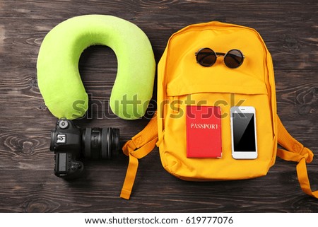 Travel pillow and things for traveling on wooden background