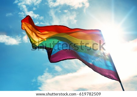 Gay flag on sky background Royalty-Free Stock Photo #619782509