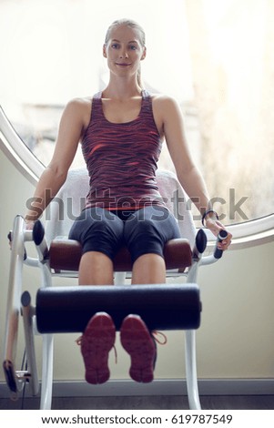 Young woman exercising legs in modern gym