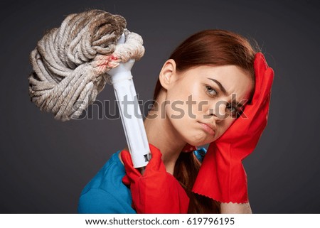 Mop woman tired with gloves on gray background