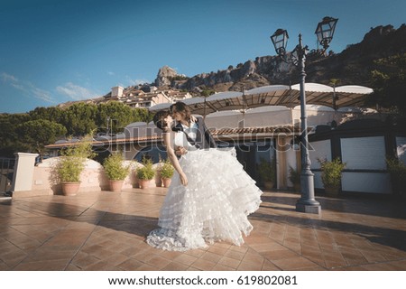 Cheerful married couple, joking and posing for some pictures, in the beautiful hotel of their honeymoon in Sicily