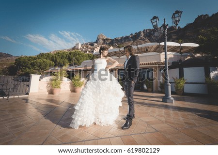 Cheerful married couple, joking and posing for some pictures, in the beautiful hotel of their honeymoon in Sicily