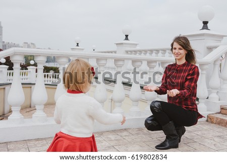 Happy loving family. Mother and child  playing, kissing and hugging. Girl in red dress. Girl running to her mom