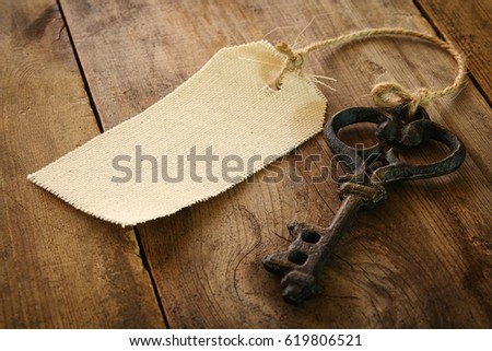 Image of antique key and empty canvas tag on old wooden table