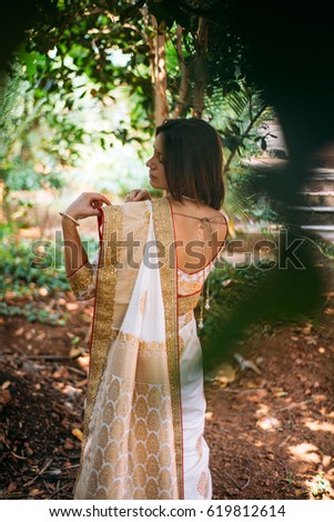 European bride in indian wedding sari, outdoor photo