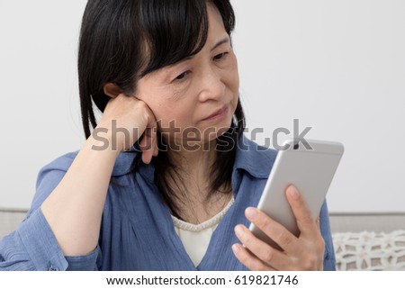 A woman using a cell phone, worried, thinking, suffering