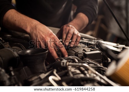mechanic fixing a car at home	 Royalty-Free Stock Photo #619844258