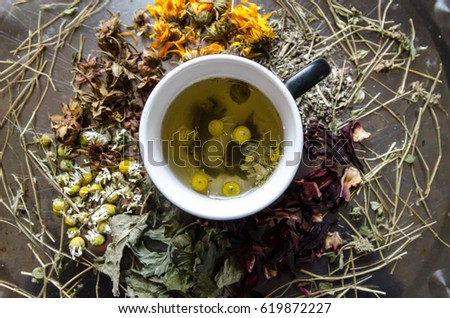 Tea from dried medicinal herbs, calendula, chamomile, mint, green tea, background for the inscription, pattern