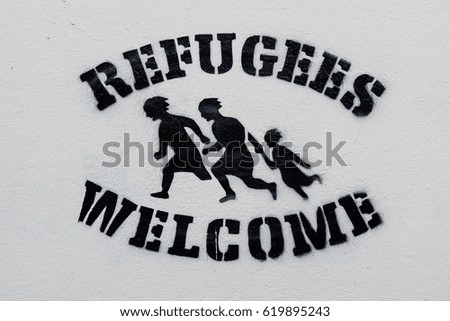 Welcome Refugees Text and Sign, Stencil Print on White Wall, Symbol