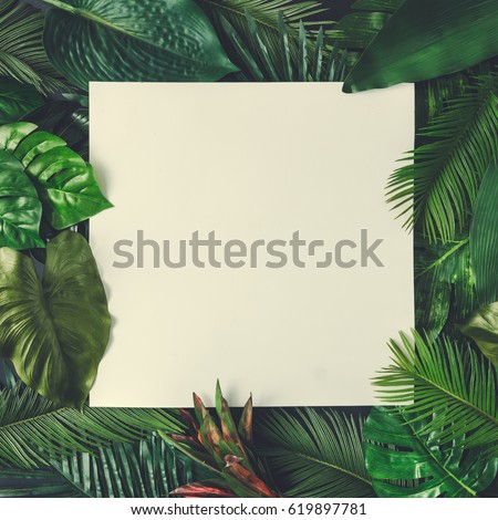 Creative nature layout made of tropical leaves and flowers With paper card note. Flat lay. Summer concept.