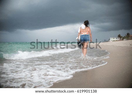 Girl Walking on a Beach during a Storm 