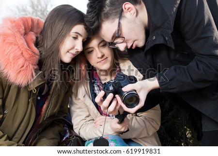 Young photographer shows photos on display to the girls