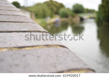 Close up of a brick ledge with a canal scenery in the background
