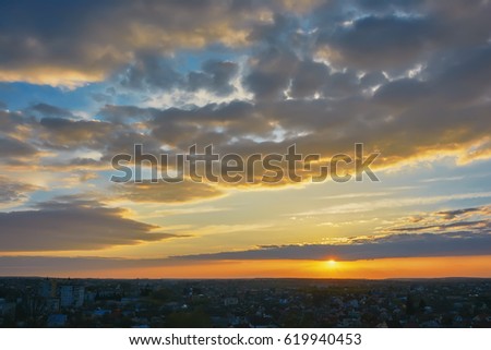 Sunset over evening city, sky with clouds.