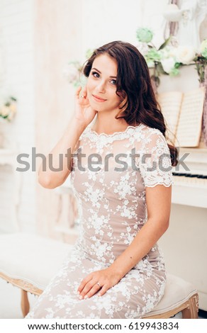 Beautiful girl in a dress playing the piano
