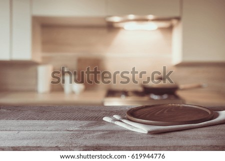 Blurred and abstract background. Empty wooden tabletop and defocused modern kitchen background for display or montage your products.