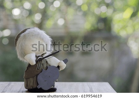 Doll Violinist on wood and background bokeh.