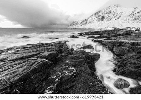 Magnificent snow-covered rocks on a sunny day. Beautiful Norway landscape. Lofoten islands. Black-white photo.