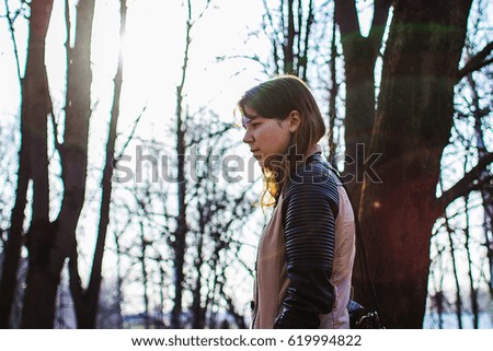 Girl is walking in the spring park in the sun