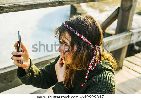 Nice hippie girl on the wood bridge in the spring sun