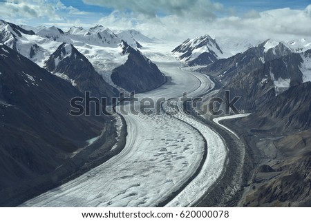 aerial photo of a glacier between mountains in alaska