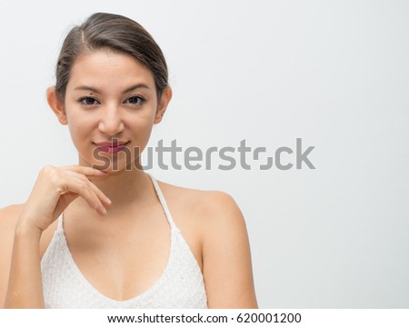 Portrait of beautiful young brunette woman with hands near face in white Dress on light gray background, Bright closeup portrait picture of beautiful woman, Age 30-40 years