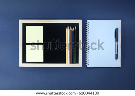 Blackboard with pencils, notebook