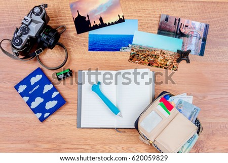 Top view. Objects of a traveller isolated on wooden background: notebook with a pen, wallet with cash and cards, passport, film, camera,  photos of turkey, italy, france  and souvenir