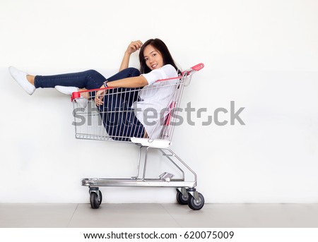 asian teen girl in shopping cart in shopaholic concept
