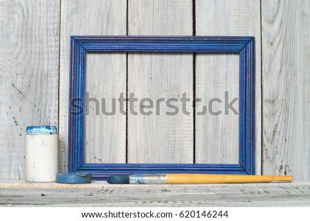 Blue frame, paint and brush on white boards background