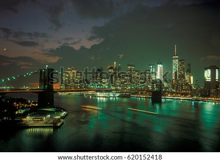 Manhattan skyline with Brooklyn Bridge at sunset.