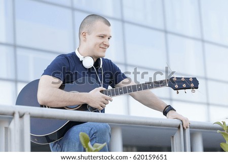 Handsome young man enjoying the outdoors with a guitar.Selective focus and small depth of field.