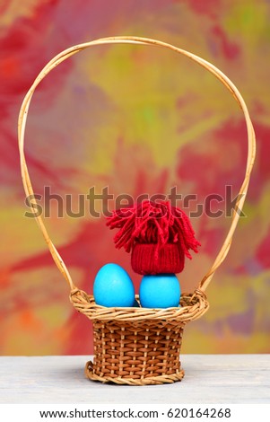 straw basket with easter blue eggs as smurfs in winter red hood or hat on colorful background, healthy food, greeting and celebration, future life, farming, copy space