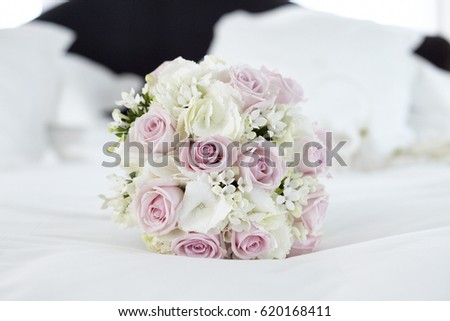 Pink and white roses bridal bouquet on a white bed. Horizontal format. Close up picture