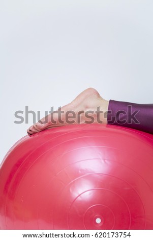 Young woman exercise with red pilates ball isolated on white