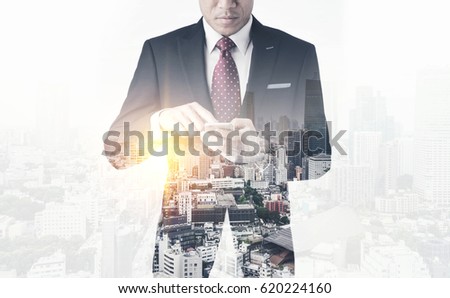 Asia business concept - thoughtful modern office man use smart phone with dark suit, stand and think the business plan. Double exposure effect with Japan city skyline background