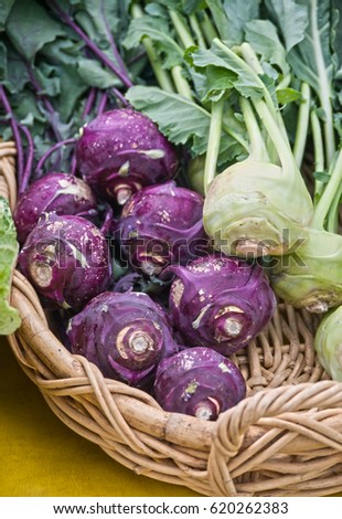 A basket of fresh organic purple and white kohlrabi are on display at a local farmer's market.  These markets have helped reduce carbon footprints by encouraging local food production and purchase.