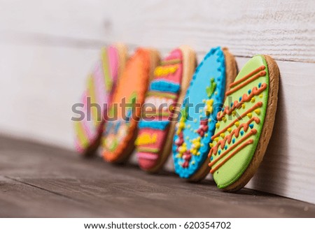 Delicious Easter cookies background. Colorful Easter cookies all over white wooden background. Eggs with different pattern icing. Top view