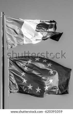 general three colors flag and Europe flag waving together in isolated the grey sky background. black and white. Concept for old financial treated, unique currency and financial bond and crisis.