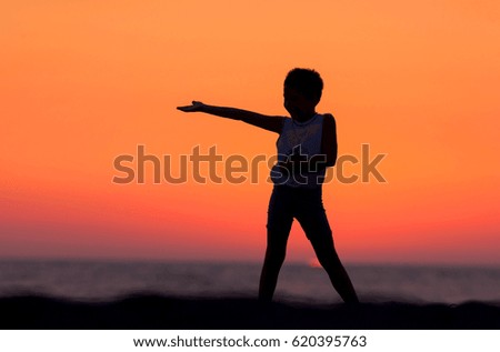 Silhouette of young boy playing on the beach