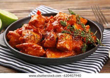 Frying pan with delicious chicken tikka masala on napkin Royalty-Free Stock Photo #620407940