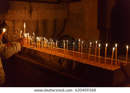 Hand with candle in the Holy Sepulchre on Mount Calvary, Jerusalem, Israel