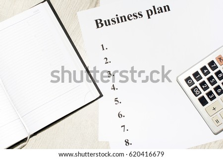 An inscription of the business plan, execution points, there is a notebook and a calculator next to it