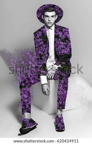artistic fashion vogue image of a man in a hat and black suit. collage with a flying flowers on his clothes